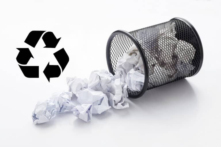 Umgefallener Papierkorb mit dem Recycling-Symbol